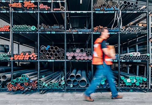 a worker carries materials through an industrial warehouse